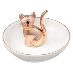 a gold cat figurine sitting on top of a white bowl with gold trim