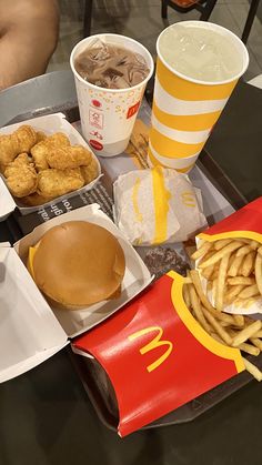 a tray that has some food on top of it and drinks in cups next to it