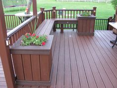 a wooden deck with benches and flowers on it