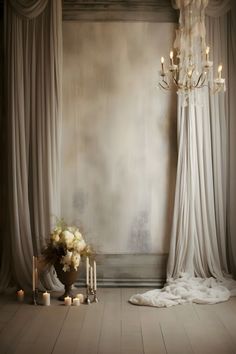 a chandelier hanging from the ceiling next to a vase with flowers and candles