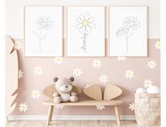 a teddy bear sitting on a wooden bench in front of three framed flower pictures and a baby's crib