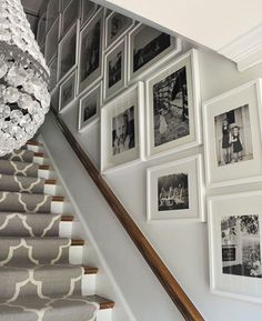 a staircase with pictures on the wall next to it