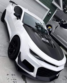 a white and black car parked in front of a house