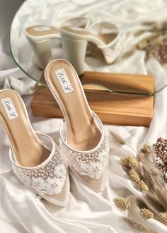 a pair of white shoes sitting on top of a bed next to a glass table