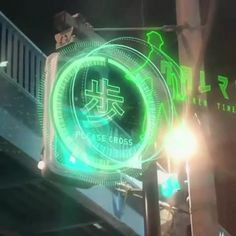 there is a green neon sign on the side of a building that says chinese times