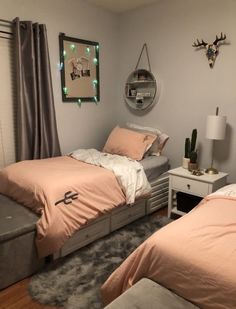 two twin beds in a bedroom with pink sheets and pillows on top of the bed