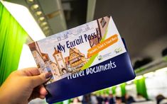 a person holding up a travel document in their hand with the words my eurail pass on it