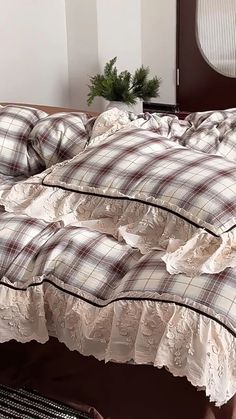 an unmade bed with white and brown plaid comforter on it's side