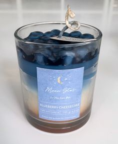 a candle with blueberries in it sitting on a table