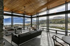 a living room filled with furniture and large windows overlooking the mountains in front of it