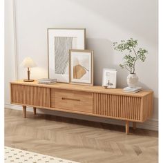 an image of a living room setting with art on the sideboard and framed pictures