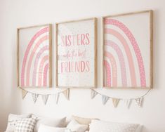 two pink and white posters hanging on the wall above a bed in a girls'bedroom