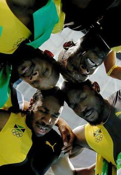 a group of young men standing next to each other in front of a camera with their faces painted yellow and green