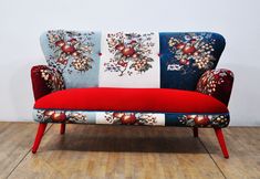 a red and blue couch sitting on top of a wooden floor