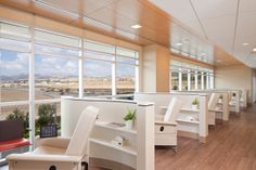 an empty office with lots of desks and chairs in front of large windows overlooking the city