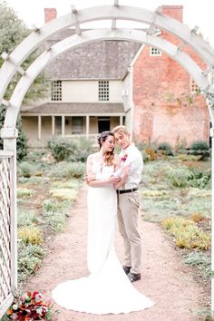 a bride and groom standing under an archway