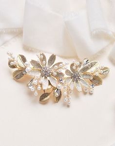 a close up of a brooch with pearls and flowers on it's side