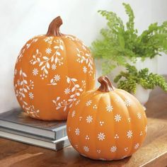 two pumpkins sitting on top of a wooden table