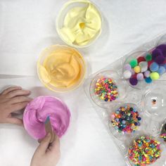 a person is decorating cupcakes with icing and sprinkles