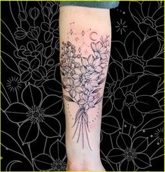 a woman's leg with flowers on it and the moon in the sky above