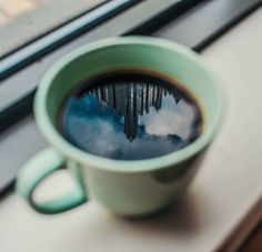 a cup of coffee sitting on top of a window sill