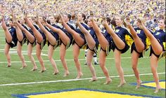 a group of cheerleaders standing on top of a field