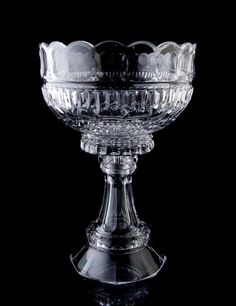 a clear glass bowl sitting on top of a black tableclothed surface with no one around it