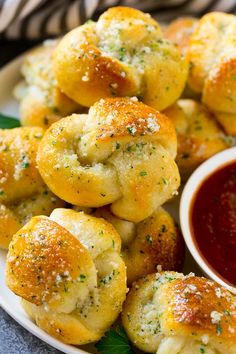 some bread rolls on a plate with dipping sauce