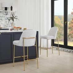 two white chairs sitting in front of a kitchen counter