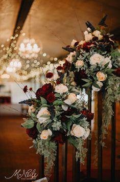 two tall vases filled with red and white flowers