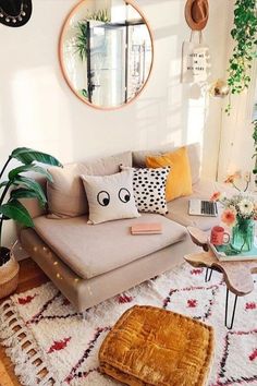 a living room filled with lots of furniture and plants on top of a white rug