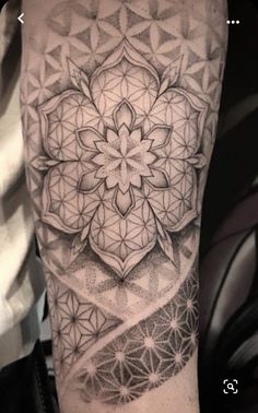 a black and white photo of a tattoo with an intricate design on the arm, done by