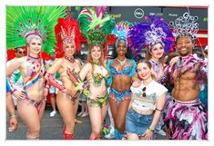 a group of people standing next to each other wearing costumes and headdresses