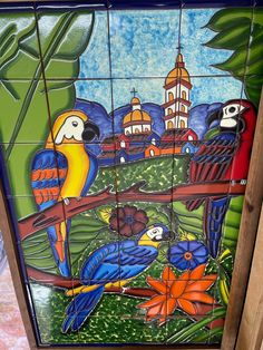 the colorful birds are painted on the tile