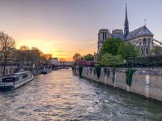 the sun is setting over an old city with boats on the water and buildings in the background