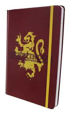 a red and yellow book with a lion on the front cover is open to show its logo