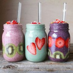 three mason jars with strawberries, kiwi and strawberry slices on them