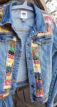 an old jean jacket is hanging on a clothes rack