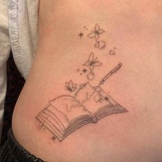 a woman's stomach with a book and butterfly tattoos on it