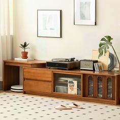 a record player is sitting on top of a wooden entertainment center in a living room