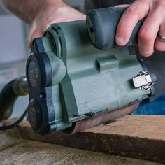 a person using a grinder to cut wood with a power tool on the table