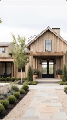 a house with lots of trees and plants in the front yard, along with a walkway leading to it