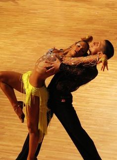 two professional dancers performing on a wooden floor