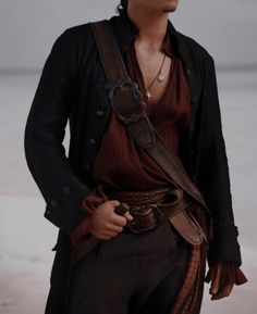 a man in pirate garb standing with his hands on his hips and looking off to the side