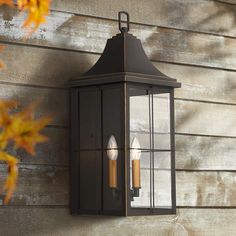 an outdoor wall light with two candles on it