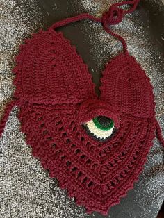 a red crocheted bag with an eye on it