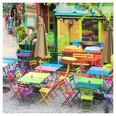 colorful tables and chairs with umbrellas outside