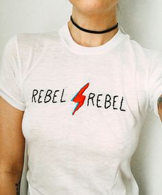 a woman wearing a white shirt with a red and blue lightning bolt on it