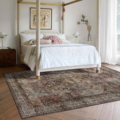 a white bed sitting on top of a wooden floor