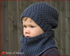 a little boy wearing a knitted hat and scarf with a hood on his head